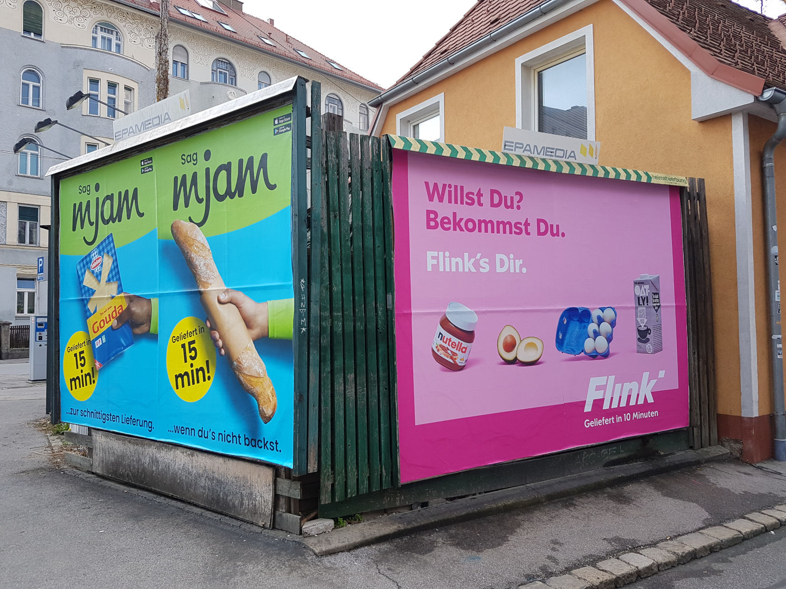 Zwei innerstädtische Plakatwände mit Werbung für Delivery-Dienste